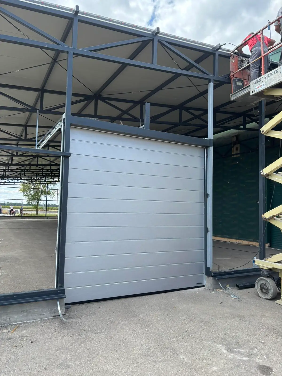 Sectional door installed in a steel-frame building opening