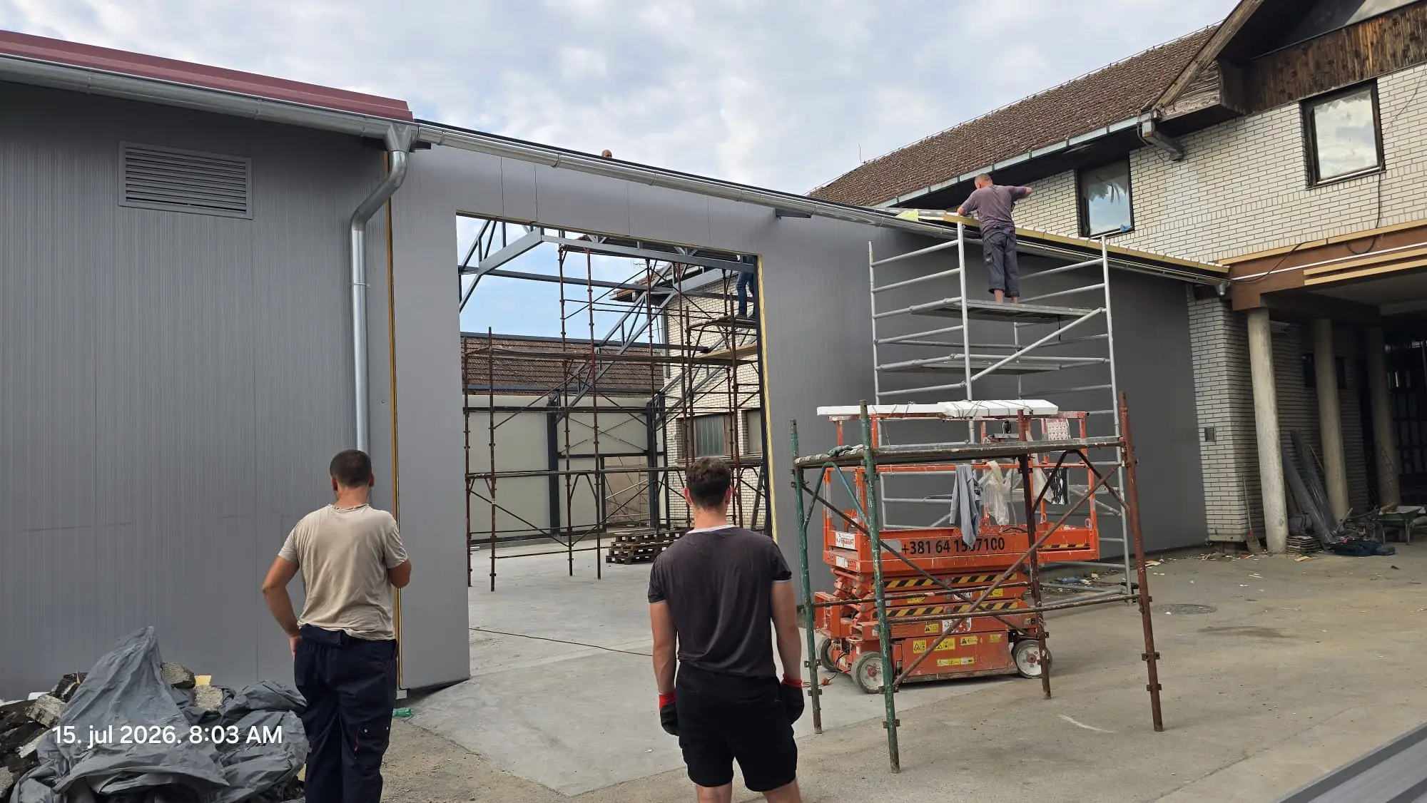 Steel canopy and gutter installation on a renovated roadside building
