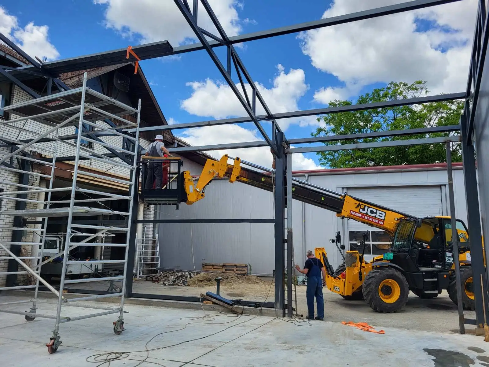 Steel-frame building under construction with a work platform lift