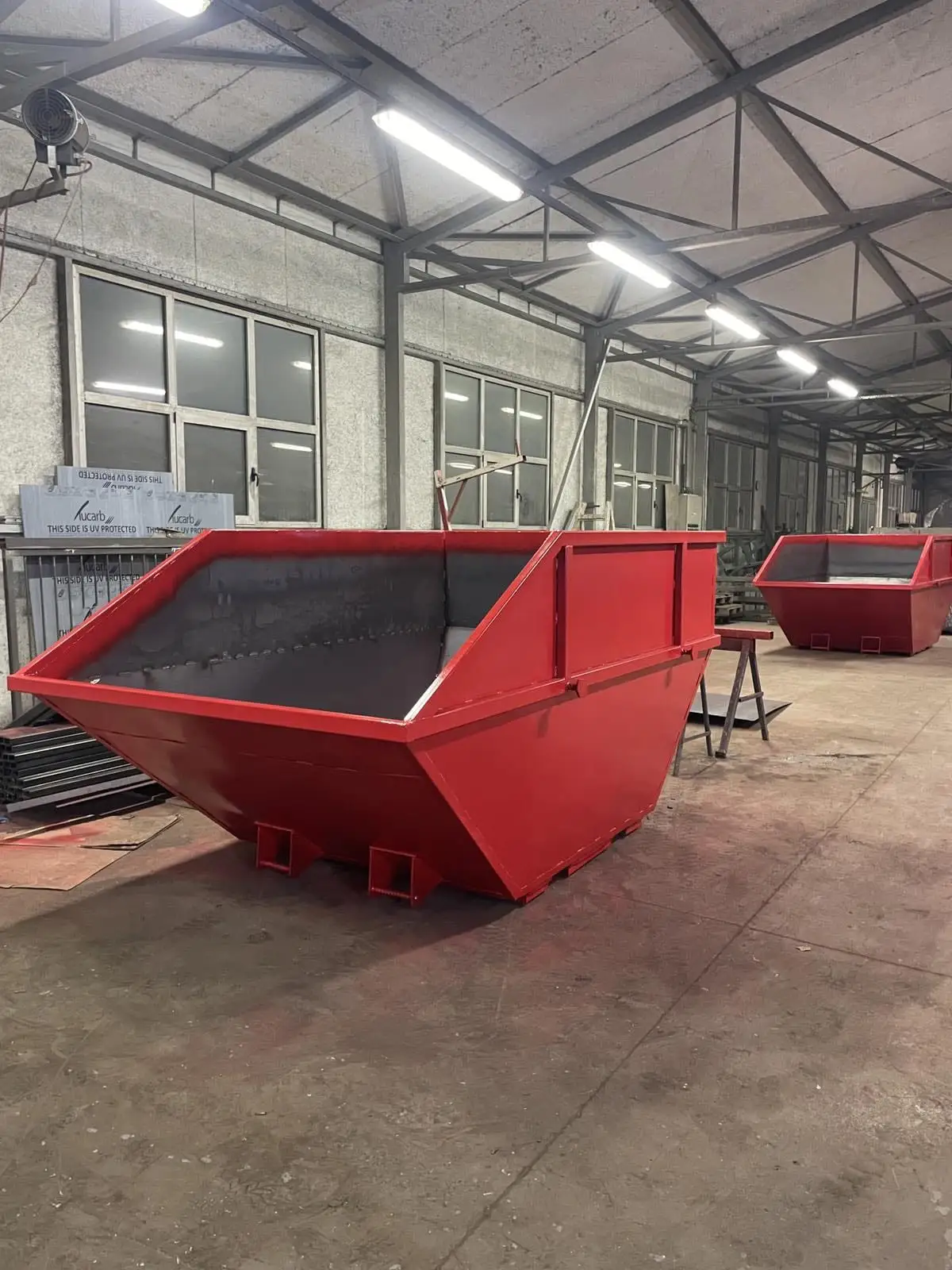 Finished powder-coated steel skip bins in the workshop