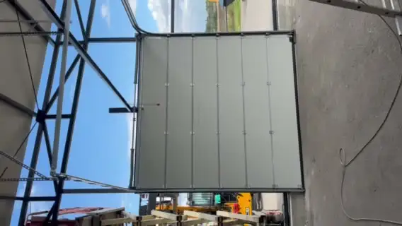 Sectional door installed in a steel-frame building opening
